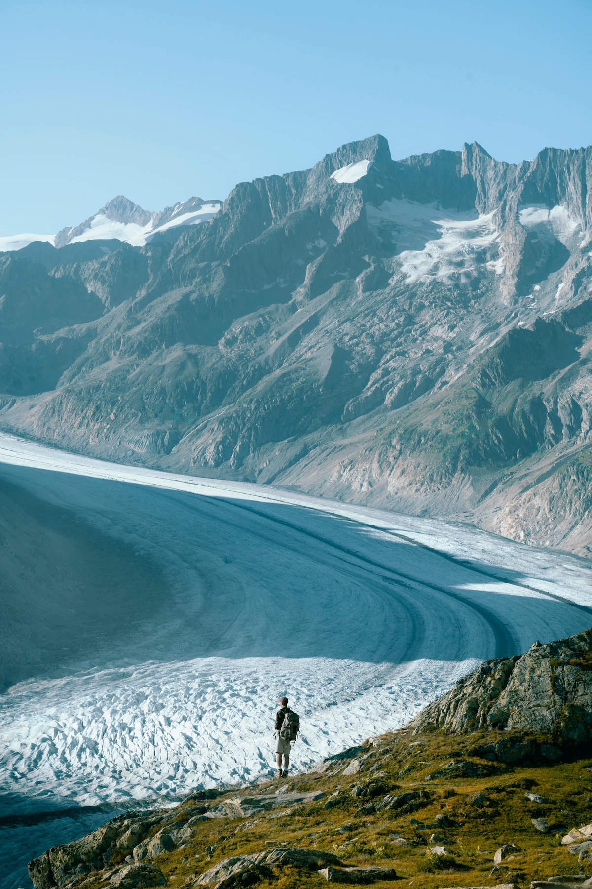 hiker stands near iceberg lake in glacier park