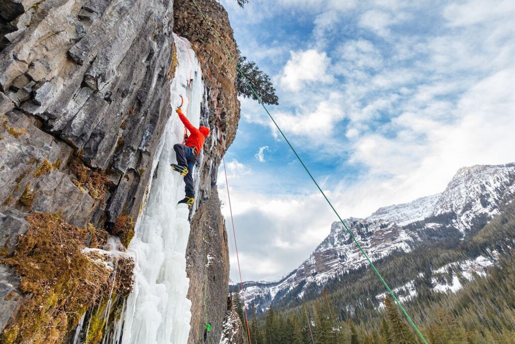 Climber in a red jacket on a column of ice during the Bozeman Ice Festival in Hyalite Canyon