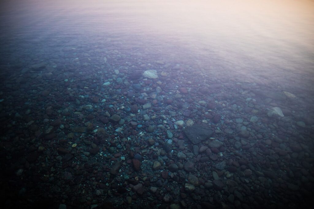 Red, green, and blue stones under the clear water of Lake McDonald in Glacier National Park