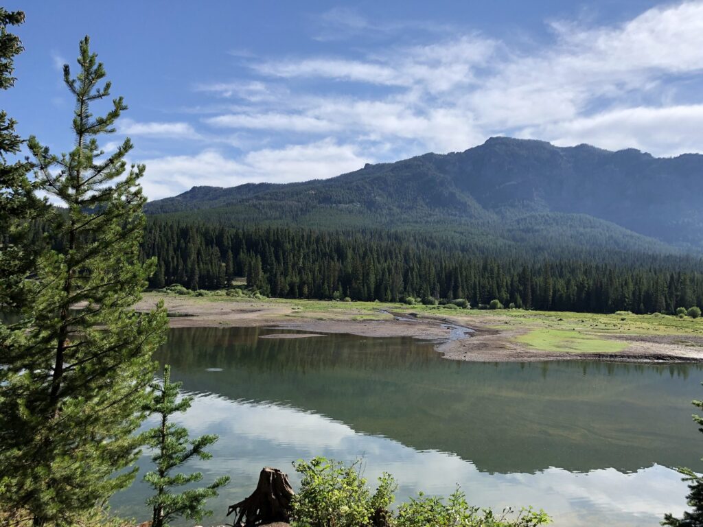 Hyalite Reservoir reflecting forested peaks along the West Shore Trail near Bozeman