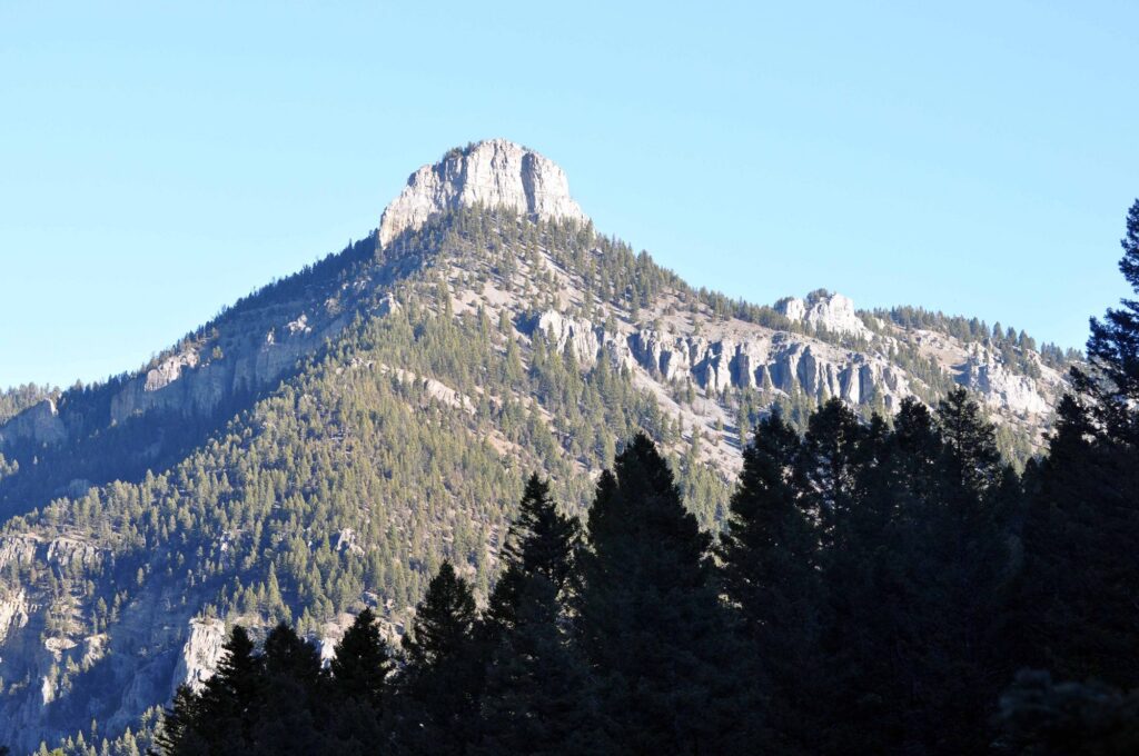 Storm Castle rock formation rising above pine forest in Gallatin Canyon near Bozeman