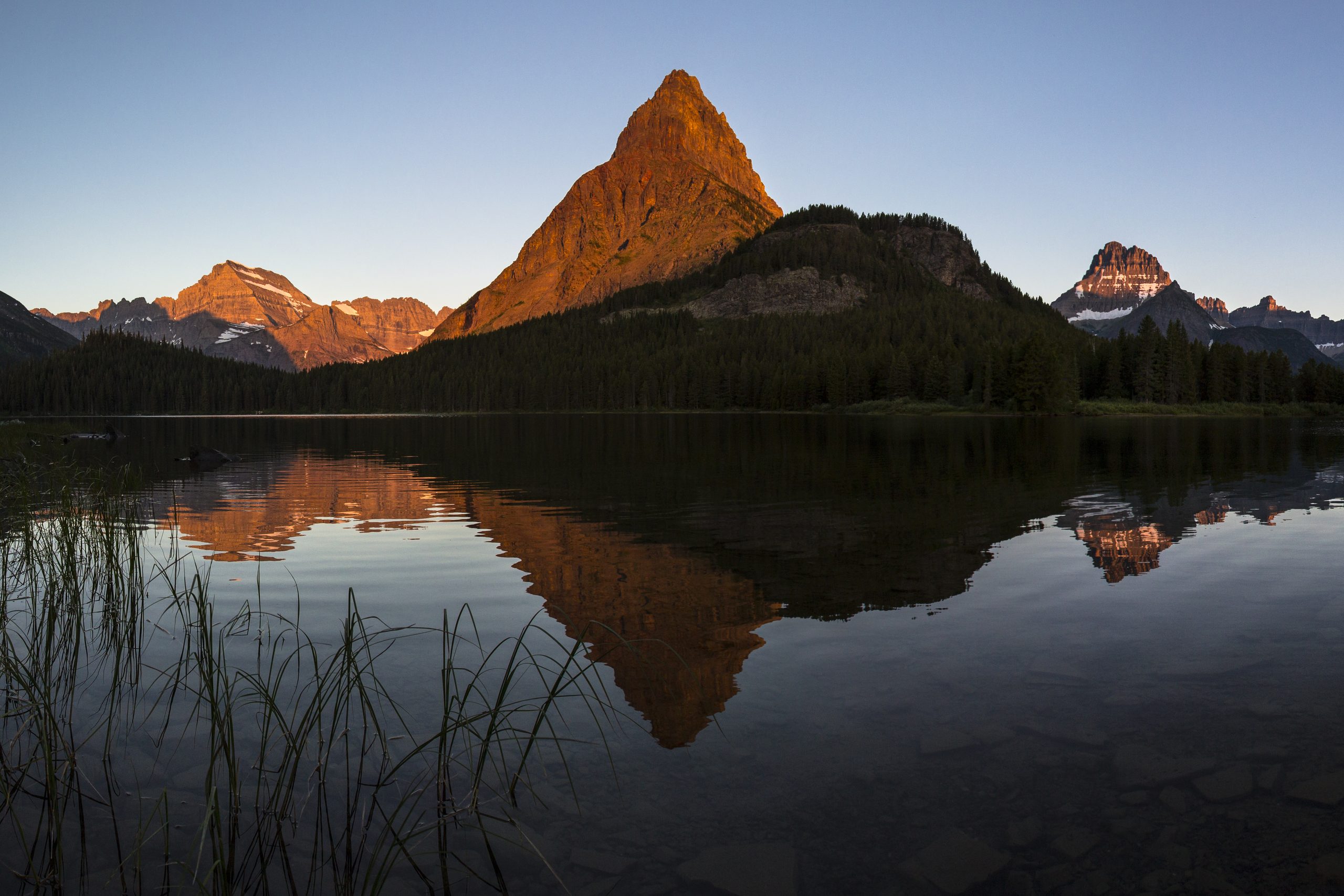 Sunrise alpenglow on Mount Grinnell reflected in Swiftcurrent Lake, Glacier National Park