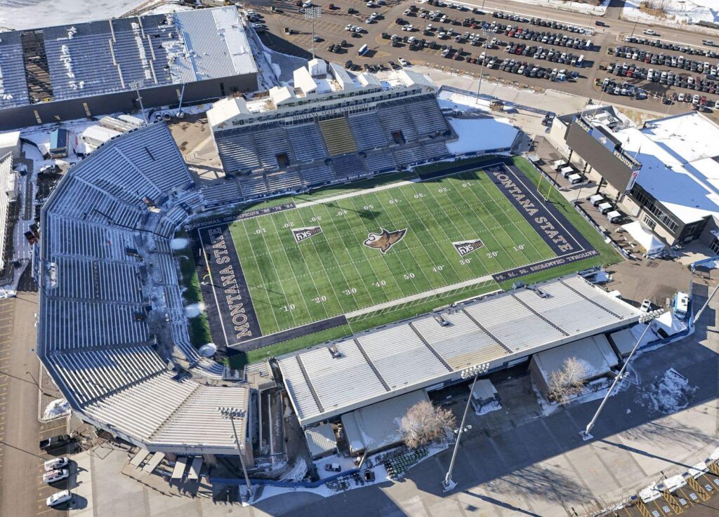 Aerial view of Bobcat Stadium at Montana State University in Bozeman, with snow on the parking lots around it