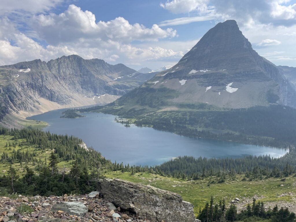 Hidden Lake seen from the overlook, with Bearhat Mountain rising above the far shore and a gray boulder in the foreground